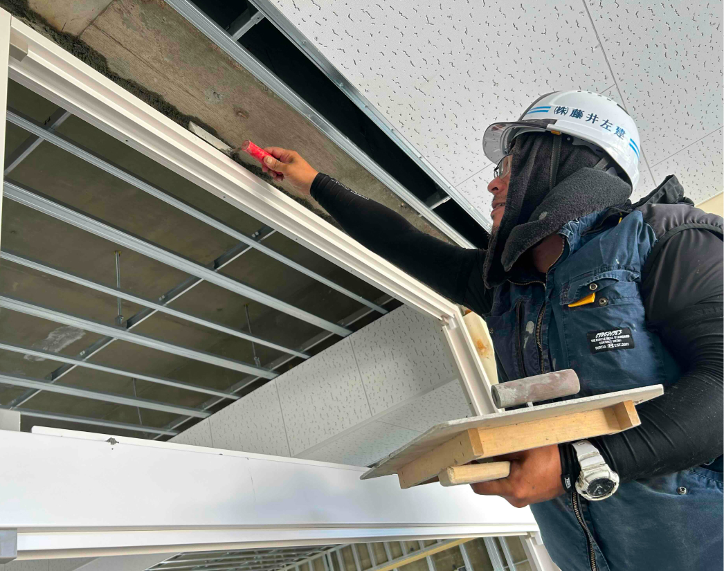 建物天井付近を施工する男性の左官